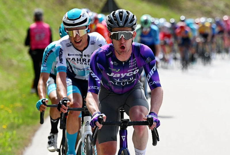 Eddie Dunbar Cyclists in a race with one in a purple jersey leading the pack.