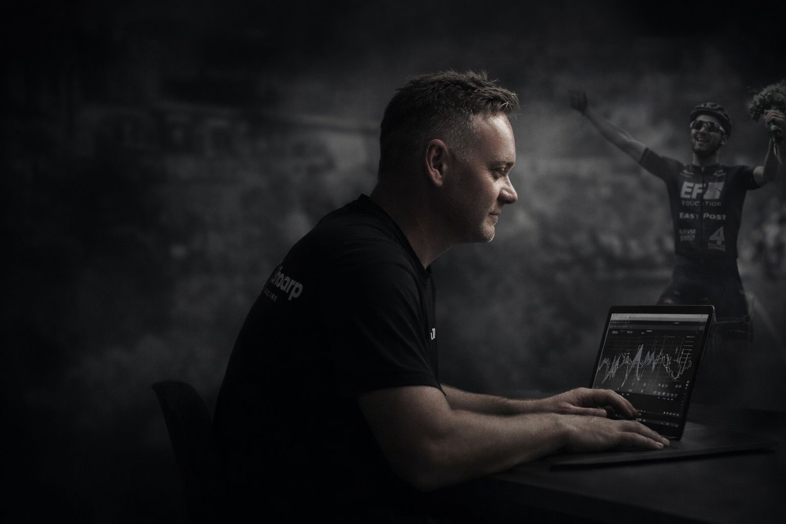 Man using a laptop with a blurred background featuring a person in athletic wear.
